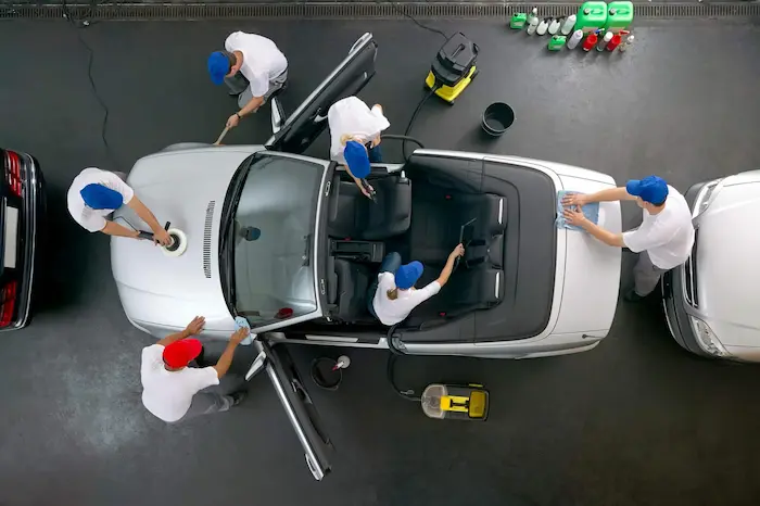 Echipă de tehnicieni care lucrează la polish și curățare auto
